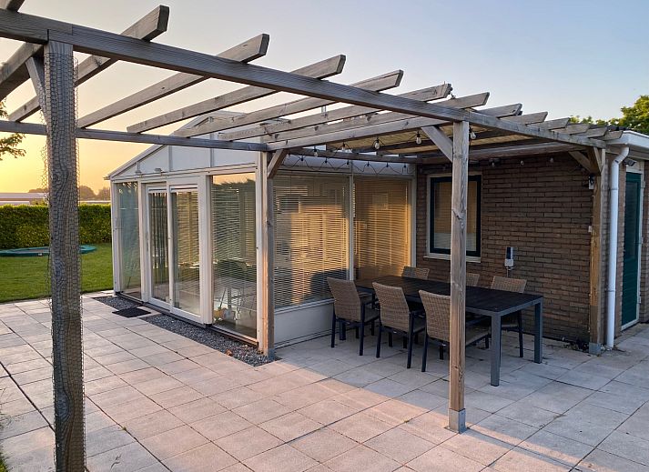 Entspannen Sie sich auf der Terrasse des Ferienhauses ZE1679 in Kamperland, Nord-Beveland, mit schoener Aussicht auf den gruenen Garten und die natuerliche Umgebung.