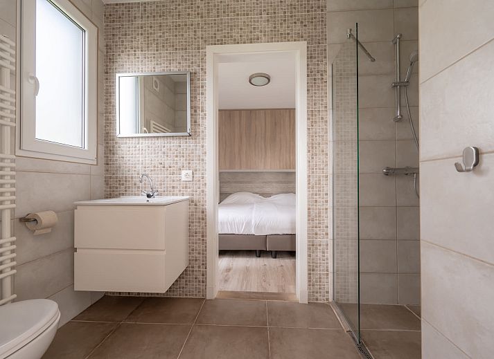 Gezellige woonkamer van Bungalow de Boei met uitzicht op de tuin in Kamperland, Noord-Beveland, Zeeland.