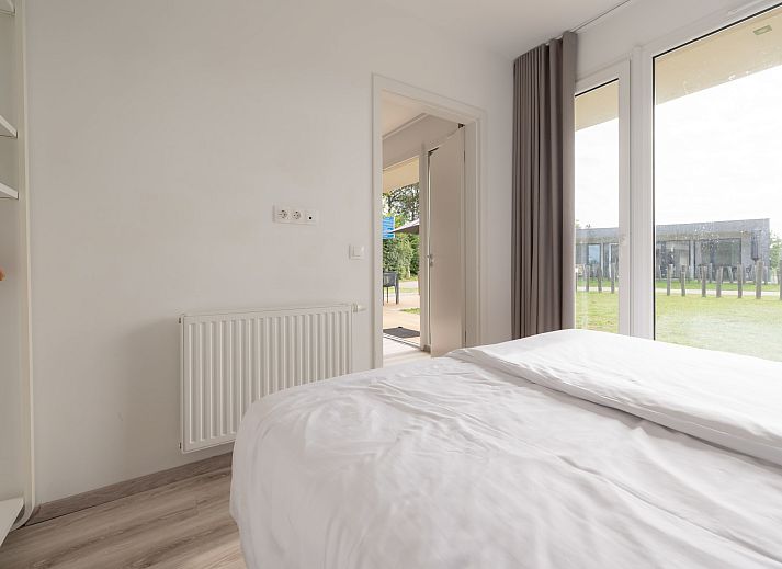 Gezellige woonkamer van Bungalow de Boei met uitzicht op de tuin in Kamperland, Noord-Beveland, Zeeland.