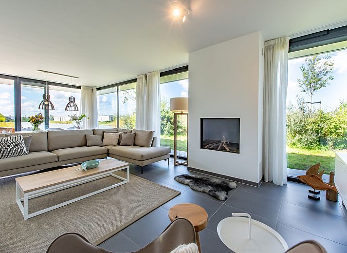 Eetkamer met uitzicht op tuin in Duinvallei 32, vakantiehuis in Kamperland, Zeeland.