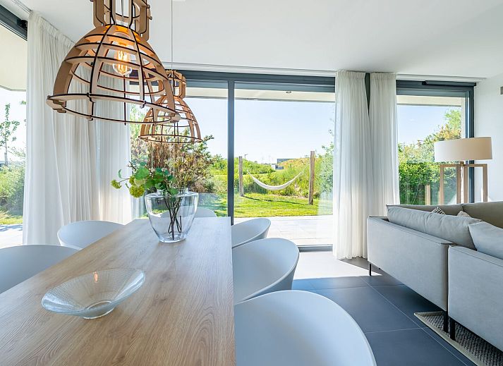 Eetkamer met uitzicht op tuin in Duinvallei 32, vakantiehuis in Kamperland, Zeeland.
