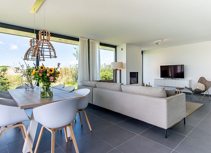 Ruime woonkamer met open haard in Duinvallei 32, vakantiehuis in Kamperland, Zeeland.