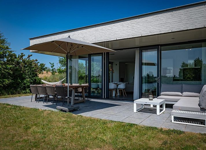 Ruime woonkamer met open haard in Duinvallei 32, vakantiehuis in Kamperland, Zeeland.