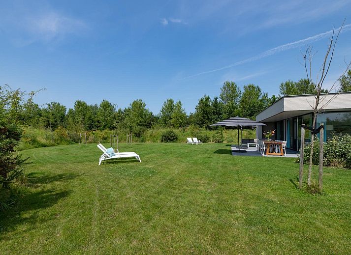 Gemuetliches Wohnzimmer in Waterline 25 | De Groote Duynen, Ferienhaus in Kamperland, Noord-Beveland, mit grossen Fenstern und Blick in die Natur.