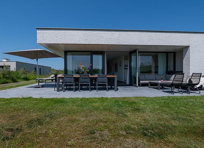 Gezellige zithoek in Duinvallei 39, De Groote Duynen, Kamperland, met comfortabele banken en een open haard.