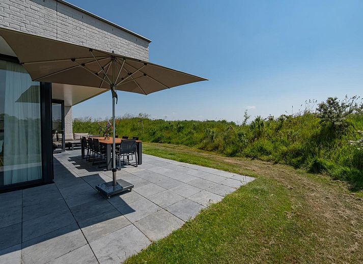 Gezellige zithoek in Duinvallei 39, De Groote Duynen, Kamperland, met comfortabele banken en een open haard.