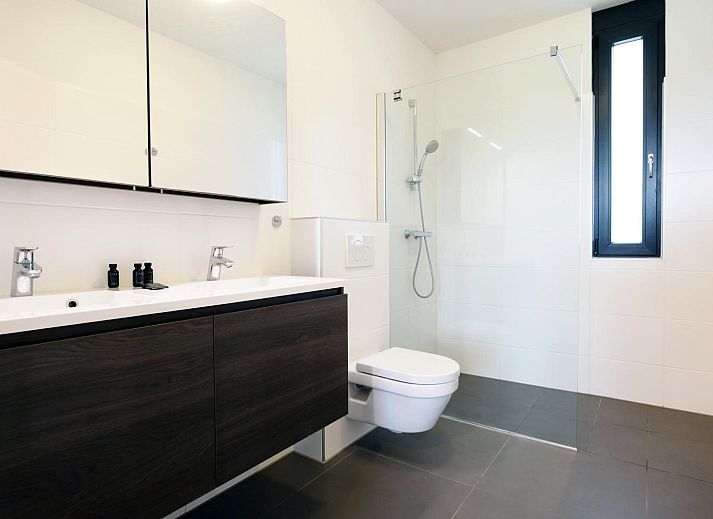 Eetkamer in Duinvallei 39, De Groote Duynen, Kamperland, met een grote houten tafel en uitzicht op de tuin.