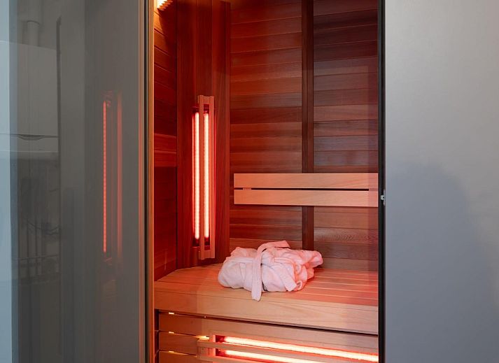 Eetkamer in Duinvallei 39, De Groote Duynen, Kamperland, met een grote houten tafel en uitzicht op de tuin.