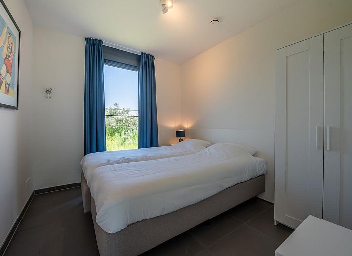 Ruime eetruimte in Duinvallei 39, De Groote Duynen, Kamperland, met moderne stoelen en een glazen wand.