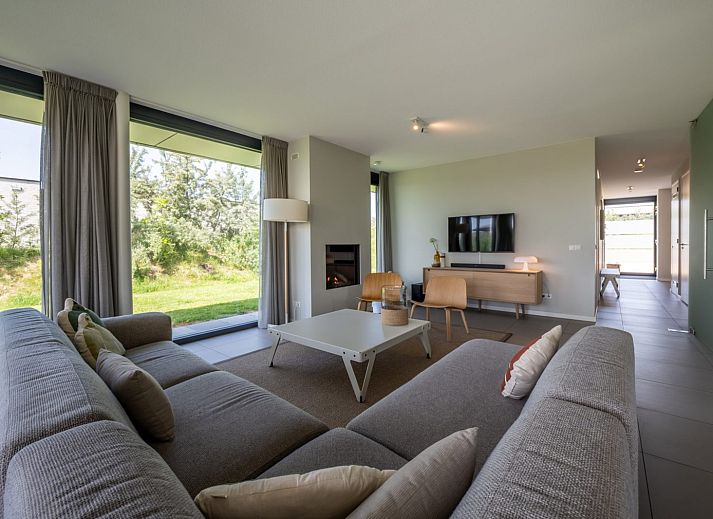 Gezellige woonkamer in Duinvallei 24 | De Groote Duynen, vakantiehuis in Kamperland met uitzicht op groene tuin.