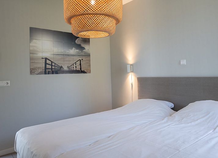 Lichte woonkamer in Duinvallei 24 | De Groote Duynen, vakantiehuis in Kamperland, met comfortabele bank en tuinzicht.