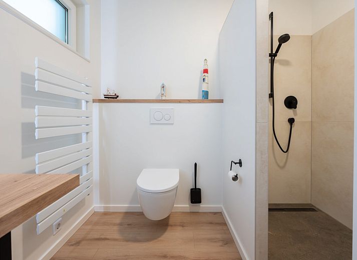 Zonnig terras met parasol bij Iepenlaan 3 | Ruiterplaat vakantiehuis in Kamperland, omringd door natuur.