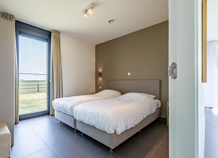 Open dining room in Duinvallei 38 | De Groote Duynen, Kamperland, with wooden table and designer chairs.