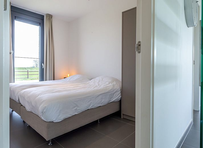 Open dining room in Duinvallei 38 | De Groote Duynen, Kamperland, with wooden table and designer chairs.