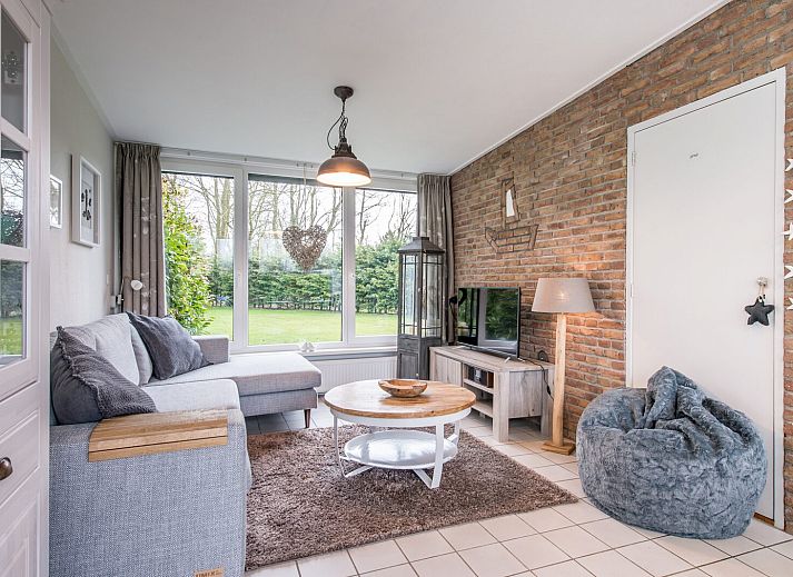 Buitenzijde van vakantiehuis Patrijzenlaan 5, De Banjaard in Kamperland, omgeven door groen en een zonnig terras.