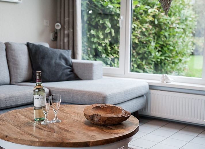 Buitenzijde van vakantiehuis Patrijzenlaan 5, De Banjaard in Kamperland, omgeven door groen en een zonnig terras.