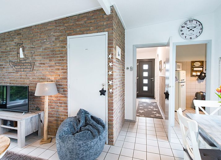 Buitenzijde van vakantiehuis Patrijzenlaan 5, De Banjaard in Kamperland, omgeven door groen en een zonnig terras.