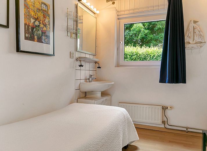 Gemuetliches Wohnzimmer in der Leeuwerikenlaan 15, De Banjaard, Kamperland mit grossen Fenstern und bequemen roten Sofas.