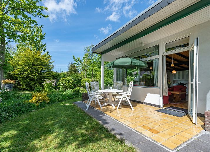 Gemuetliches Wohnzimmer in der Leeuwerikenlaan 15, De Banjaard, Kamperland mit grossen Fenstern und bequemen roten Sofas.