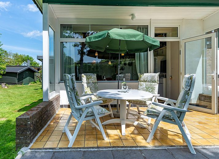 Helles Esszimmer im Ferienhaus Lark Avenue 15, Kamperland, mit Holzdecke und bunten Blumen.