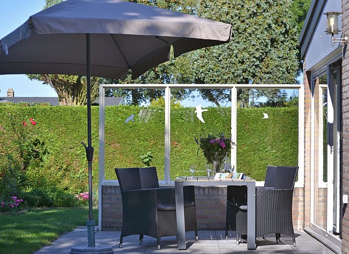 Sonniger Garten mit Terrasse und Sonnenschirm im Ferienhaus Saturnuslaan 14 Rancho Grande in Kamperland, Noord-Beveland, Zeeland.
