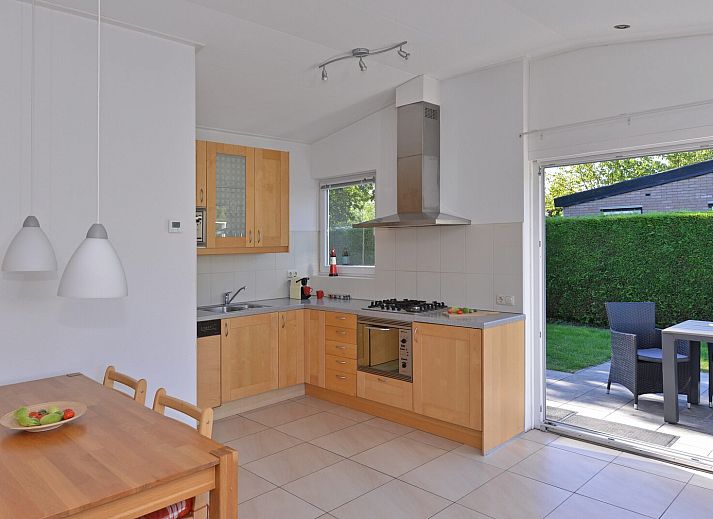 Sonniger Garten mit Terrasse und Sonnenschirm im Ferienhaus Saturnuslaan 14 Rancho Grande in Kamperland, Noord-Beveland, Zeeland.