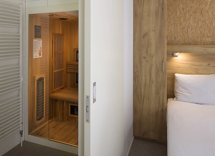 Gemuetliches Wohnzimmer im RP4 Wellness-Chalet, Kamperland, Zeeland, mit bequemem Sofa und Blick auf die gruene Umgebung.