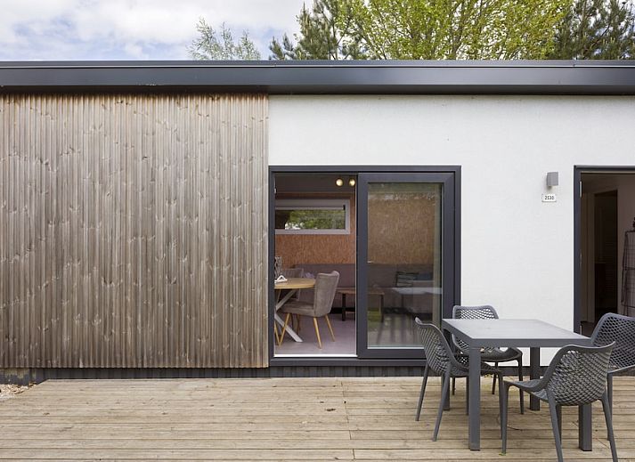 Gemuetliches Wohnzimmer im RP4 Wellness-Chalet, Kamperland, Zeeland, mit bequemem Sofa und Blick auf die gruene Umgebung.