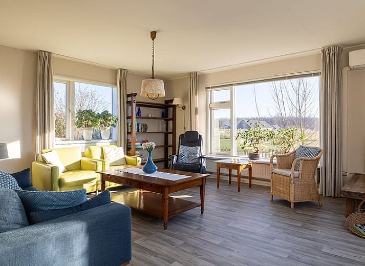 Slaapkamer met groot raam in Vakantiehuisje in Kamperland, Noord-Beveland, met uitzicht op de natuur van Zeeland.