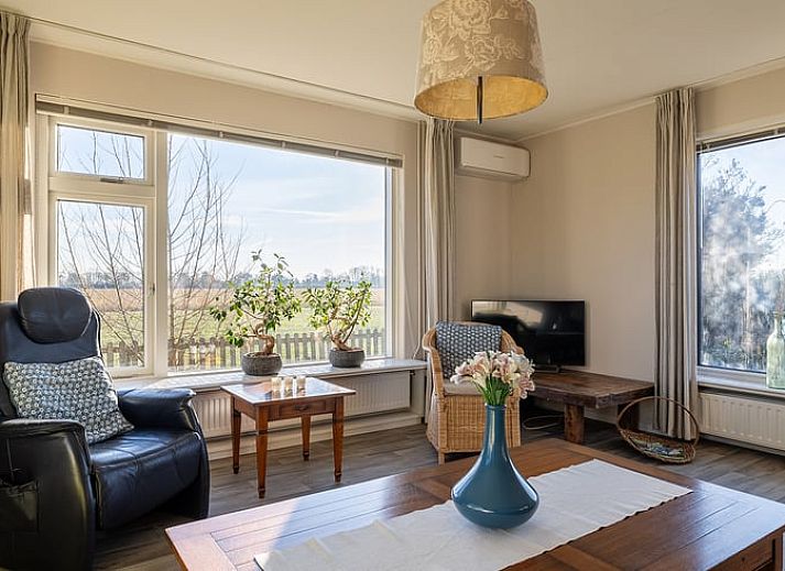 Slaapkamer met groot raam in Vakantiehuisje in Kamperland, Noord-Beveland, met uitzicht op de natuur van Zeeland.