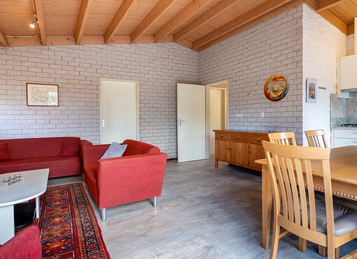 Gemuetliches Wohnzimmer im Ferienhaus Zwanenlaan 19, De Schotsman, Kamperland, mit Blick auf den gruenen Garten.