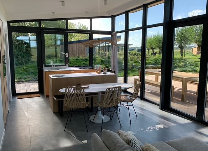 Veranda des Ferienhauses in Kamperland mit bequemen Stuehlen und Blick auf die Natur in Zeeland.