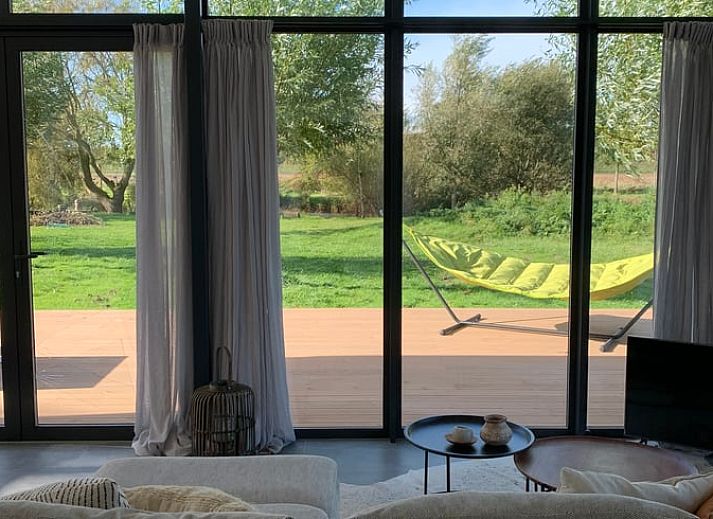 Veranda des Ferienhauses in Kamperland mit bequemen Stuehlen und Blick auf die Natur in Zeeland.