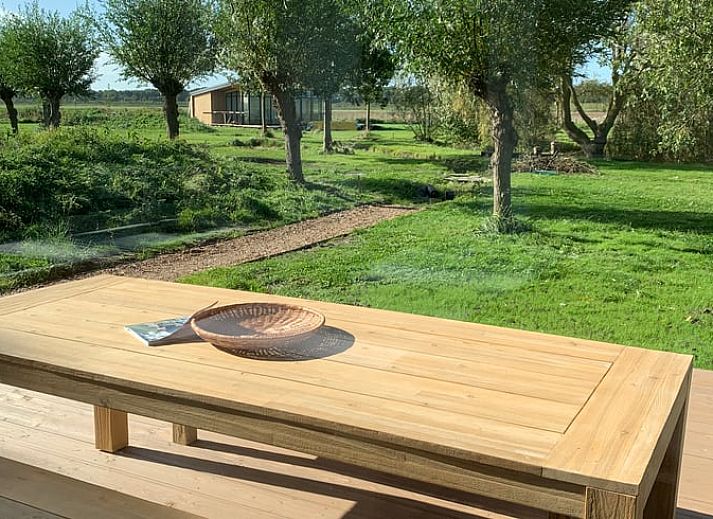 Ferienhaus in Kamperland mit Blick auf einen ruhigen Teich, umgeben von Natur in Nord-Beveland, Zeeland.