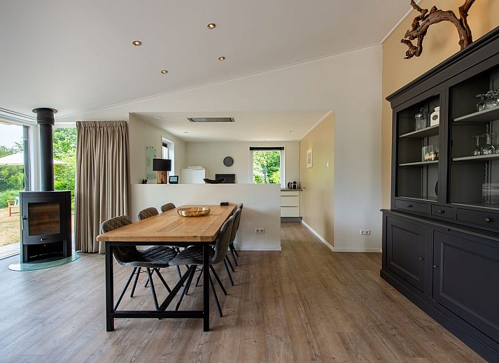 Spacious living room in vacation home Dennenlaan 17 | Ruiterplaat, Kamperland, overlooking green garden in Noord-Beveland, Zeeland.