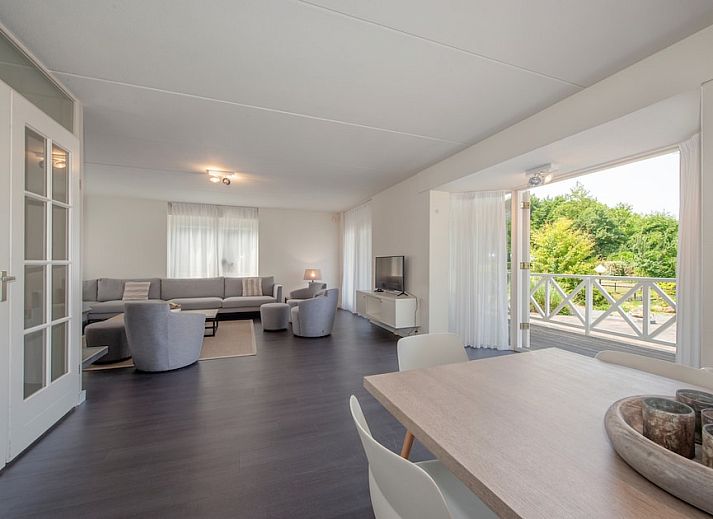 Villa R10B in Kamperland, ein charmantes Ferienhaus in Nord-Beveland, Zeeland, mit einer einladenden Veranda und einem schoenen Garten.