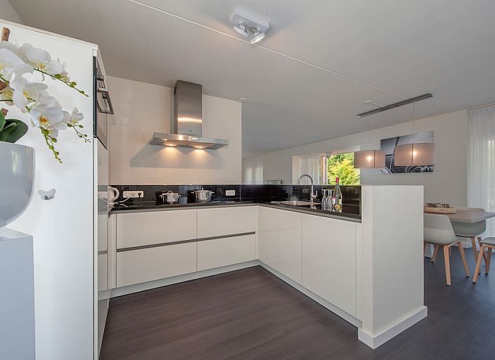 Villa R10B in Kamperland, ein charmantes Ferienhaus in Nord-Beveland, Zeeland, mit einer einladenden Veranda und einem schoenen Garten.