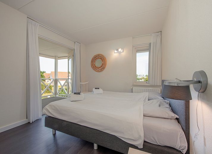 Villa R10B in Kamperland, ein charmantes Ferienhaus in Nord-Beveland, Zeeland, mit einer einladenden Veranda und einem schoenen Garten.