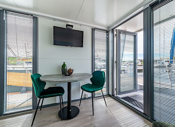 Gezellige woonkamer in Waterlodge Blue Lagoon, Marina Kamperland, met uitzicht op de boten in Noord-Beveland.