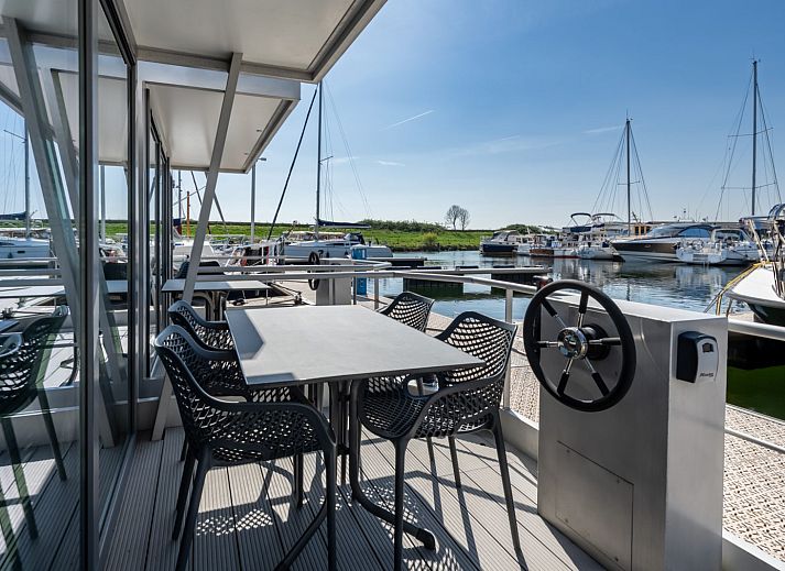 Gezellige woonkamer in Waterlodge Blue Lagoon, Marina Kamperland, met uitzicht op de boten in Noord-Beveland.
