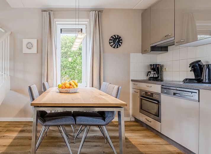 Gezellige woonkamer in Villa 4A, vakantiehuis in Kamperland, Zeeland. Comfortabele zithoek met uitzicht op de groene tuin.