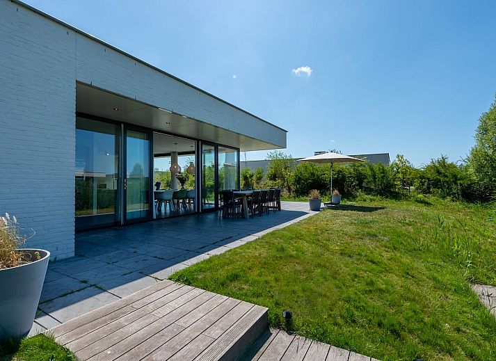 Comfortabele zithoek in Zandbank 09 | De Groote Duynen, Kamperland, met grijze bank en blauwe stoel.