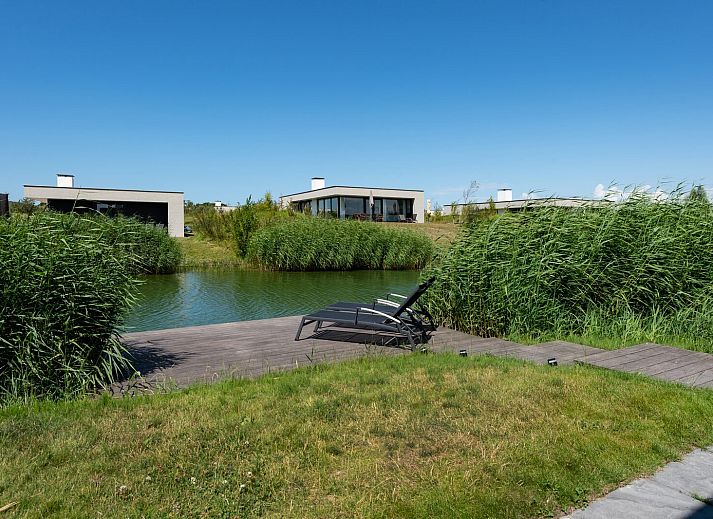 Comfortabele zithoek in Zandbank 09 | De Groote Duynen, Kamperland, met grijze bank en blauwe stoel.