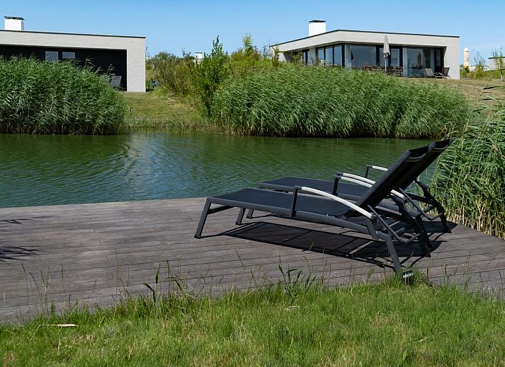 Comfortabele zithoek in Zandbank 09 | De Groote Duynen, Kamperland, met grijze bank en blauwe stoel.