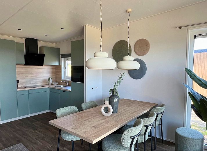 Chalet de Golfbreker in Kamperland, Noord-Beveland, Zeeland mit moderner Veranda und gruener Umgebung.