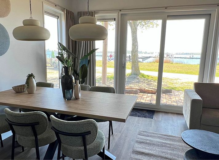 Chalet de Golfbreker in Kamperland, Noord-Beveland, Zeeland mit moderner Veranda und gruener Umgebung.