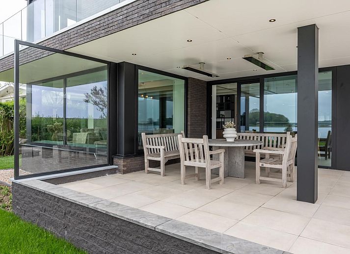 Stijlvolle entree van Sternlaan 9 | De Schotsman, Kamperland, met moderne trap en kunst in Noord-Beveland, Zeeland.