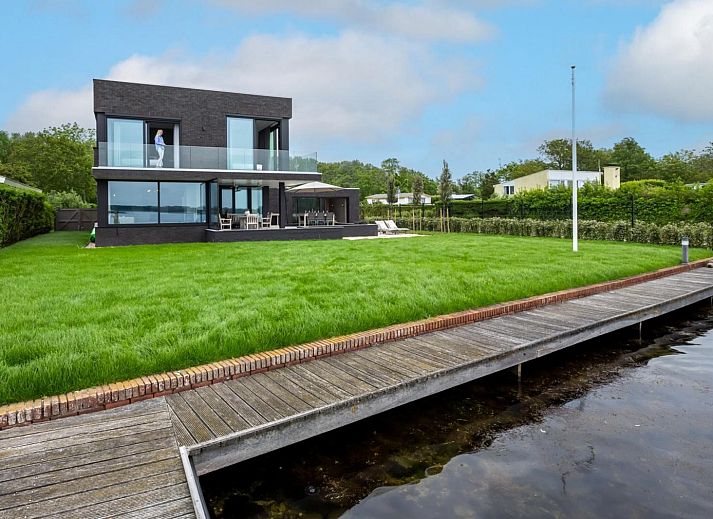 Stijlvolle entree van Sternlaan 9 | De Schotsman, Kamperland, met moderne trap en kunst in Noord-Beveland, Zeeland.