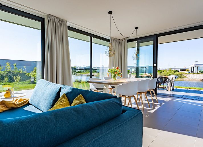 Lichte woonkamer in Waterlijn 03 | De Groote Duynen, vakantiehuis in Kamperland, Noord-Beveland, Zeeland met uitzicht op tuin.