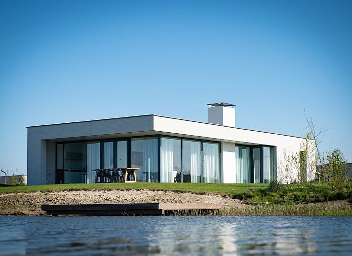 Lichte woonkamer in Waterlijn 03 | De Groote Duynen, vakantiehuis in Kamperland, Noord-Beveland, Zeeland met uitzicht op tuin.